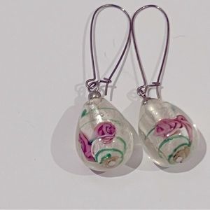 White glass bead drop earrings with green and pink swirl pattern inside